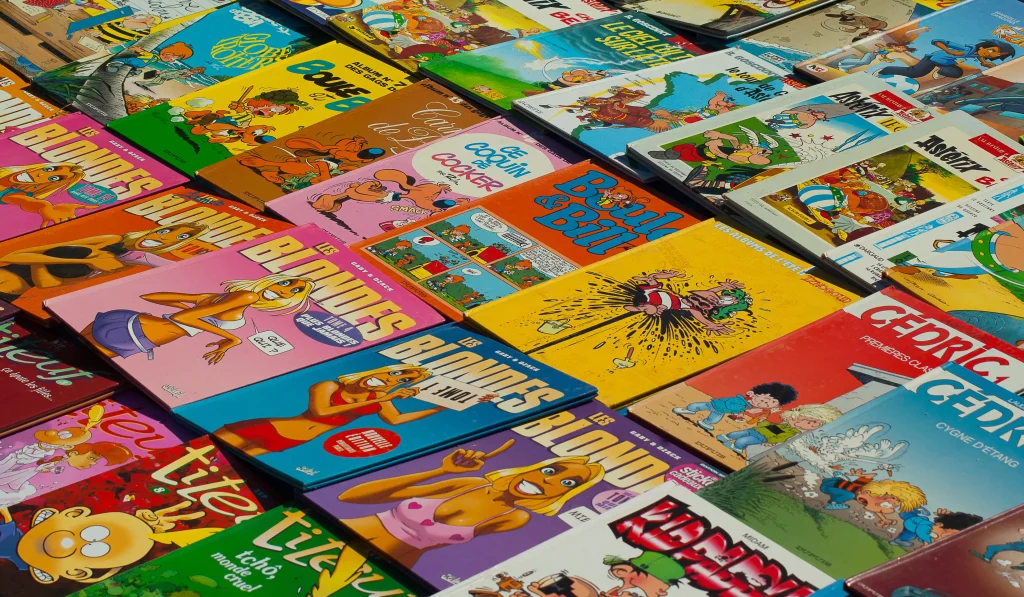 Colección de cómics y revistas ilustradas dispuestas en una mesa, mostrando portadas coloridas y estilo clásico europeo.