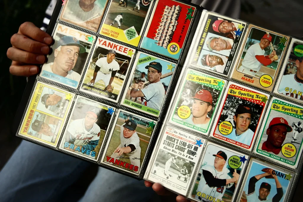 Álbum de tarjetas de béisbol vintage con jugadores históricos de la MLB, mostrado en manos de un coleccionista.