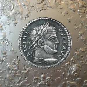 Denario romano antiguo con retrato imperial sobre fondo metálico texturizado, ideal para ilustrar la historia de la numismática.