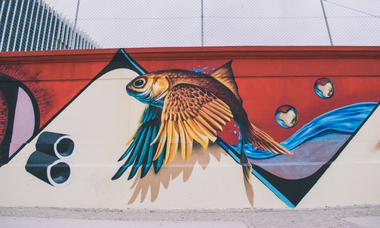 Mural de arte urbano pintado en un muro exterior, con estilo graffiti contemporáneo y colores vibrantes, representativo de la cultura urbana moderna.