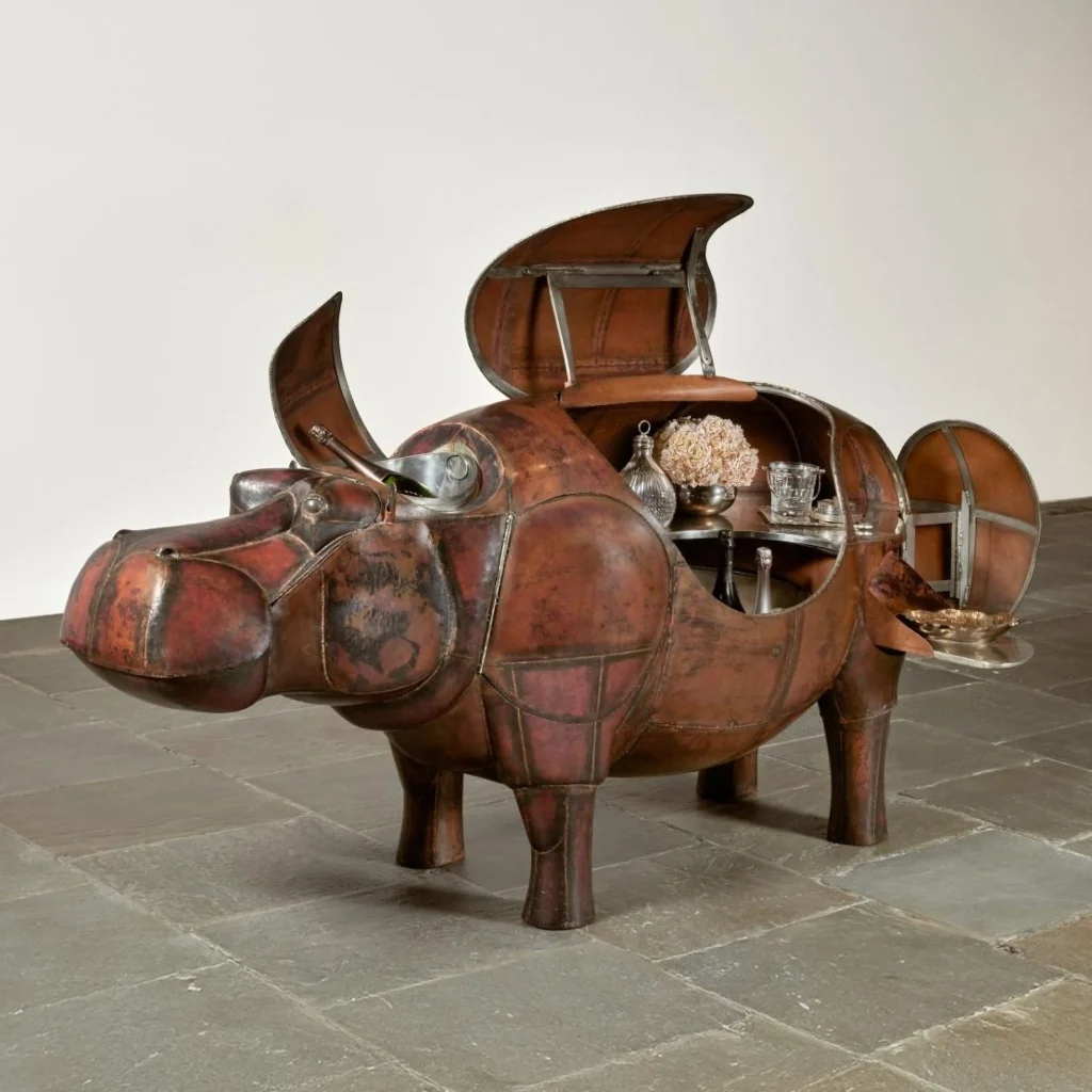 Escultura funcional en forma de hipopótamo de cobre con compartimentos abiertos mostrando bar interior, diseño de François-Xavier Lalanne