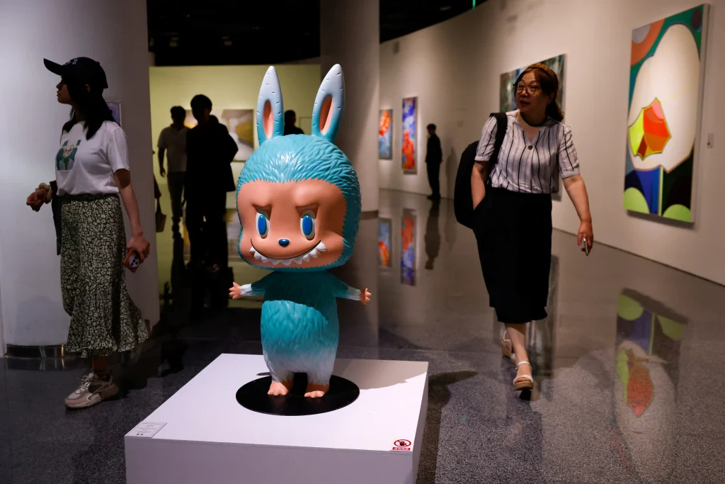 Figura de colección estilo diseño artístico tipo Labubu exhibida en galería antes de subasta pública en Beijing