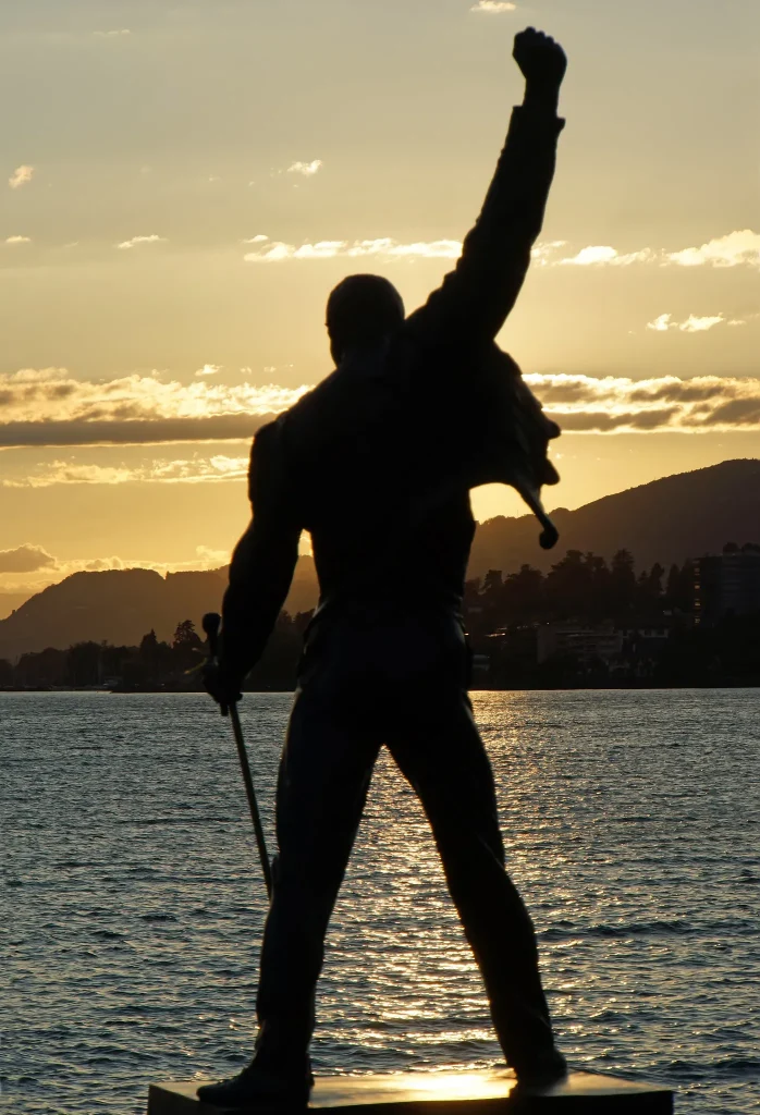 Silueta de la estatua de Freddie Mercury frente al lago de Ginebra al atardecer en Montreux, Suiza.